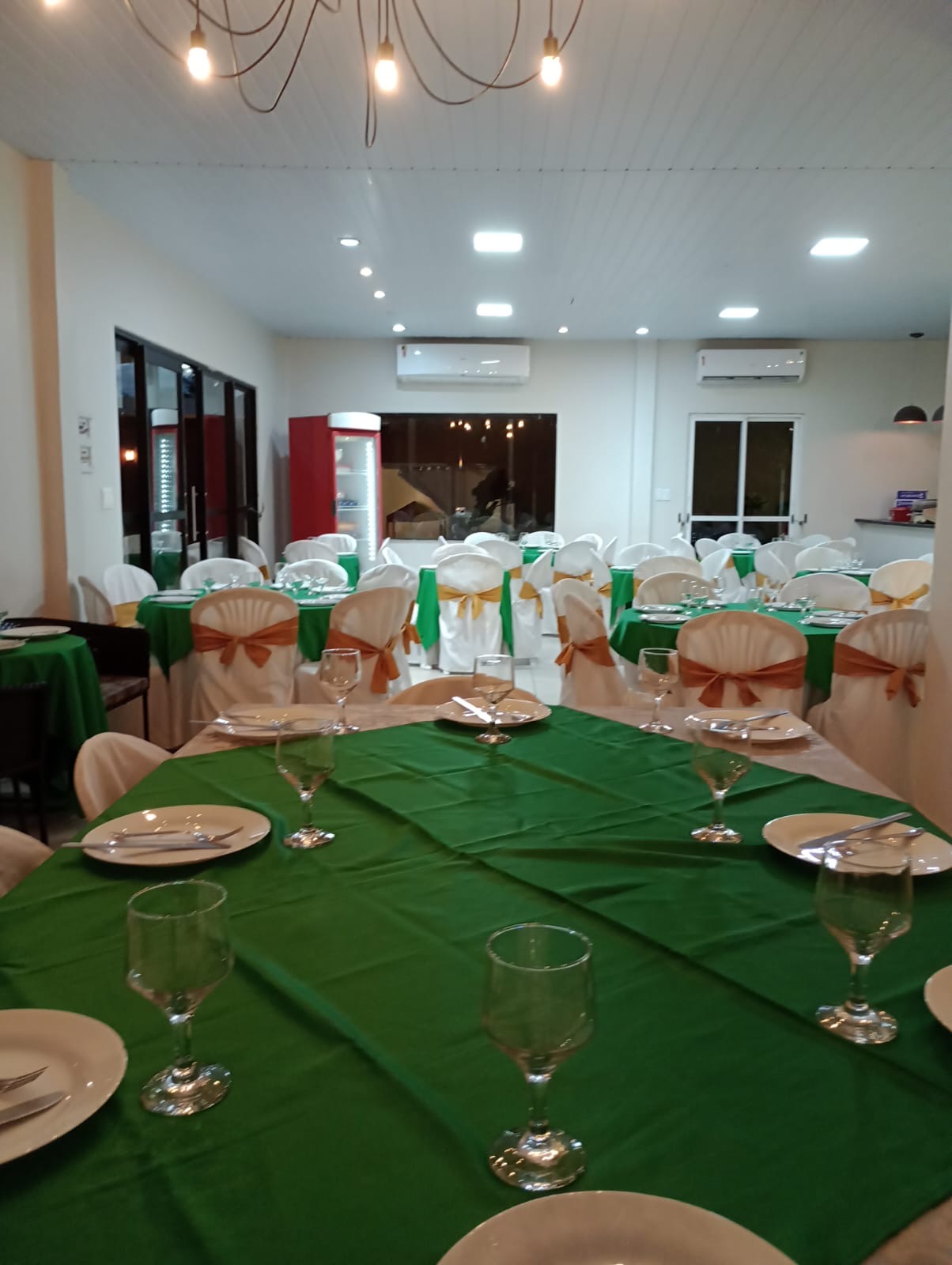 Salão da Casa Bella montado com mesas e cadeiras para evento em Manaus